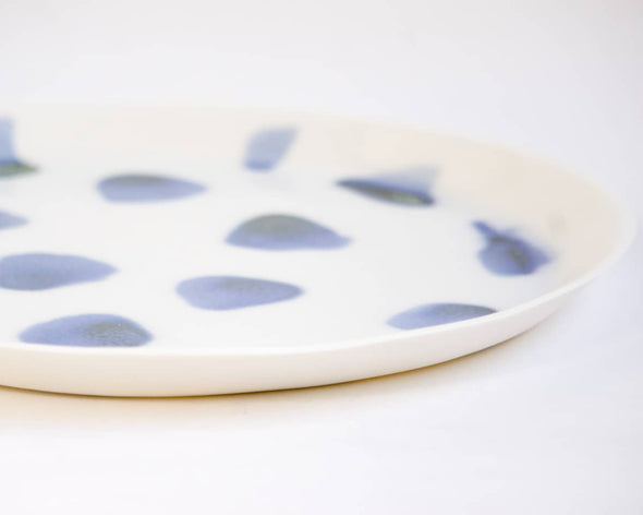 Zoom finesse de la porcelaine de l'assiette ronde plate design blanche tachetée