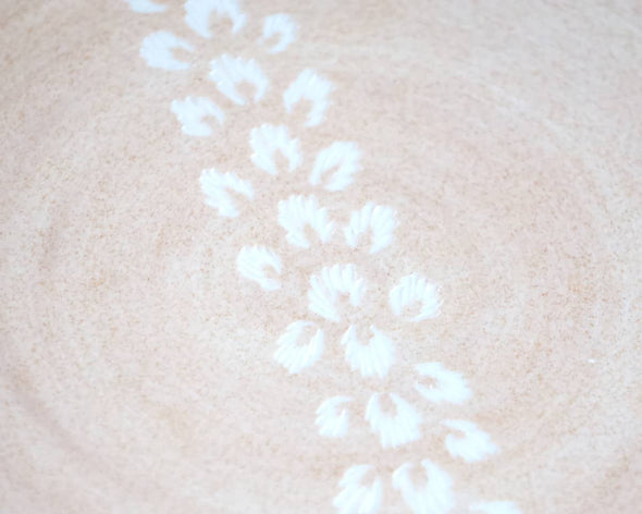 Assiette porcelaine rose sable motifs blancs