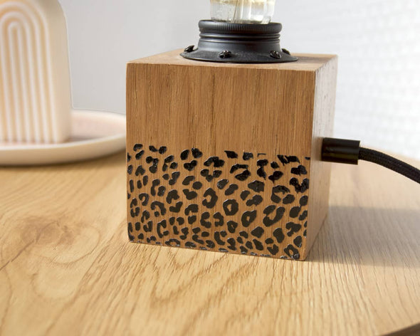 Lampe en bois à poser artisanale zoom sur motifs léopard noirs