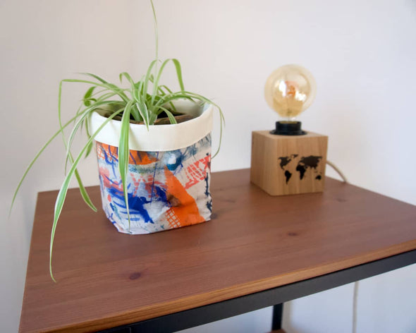 Cache-pot design en tissu artisanal motifs uniques sserigrpahiés à la main avec plante et lampe sur une étagère