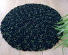 Tapis rond tendance vert noir artisanal en crochet pour décoration salon avec plante