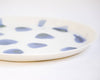Zoom finesse de la porcelaine de l'assiette ronde plate design blanche tachetée