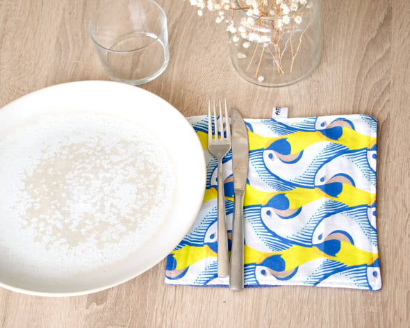 Table dressée avec serviette de table en coton fait-main motif tropical original perroquets jaunes et bleus