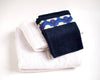 gants de toilette bleu marine sur serviette pour décoration de salle de bain