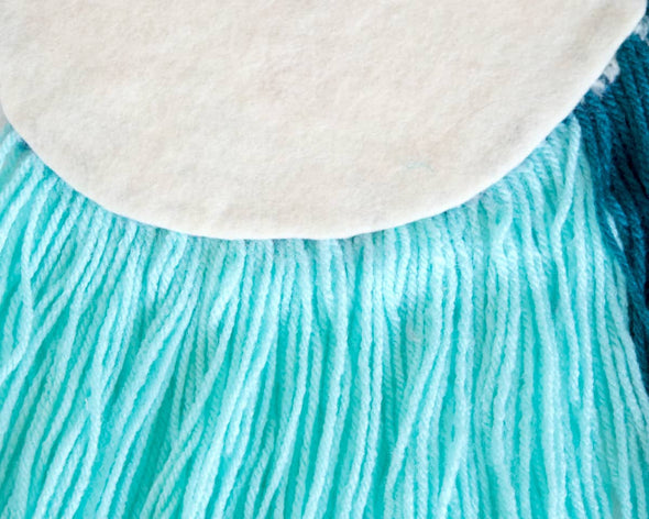 Zoom franges en laine bleues et verte du tufting deco artisanal made in France