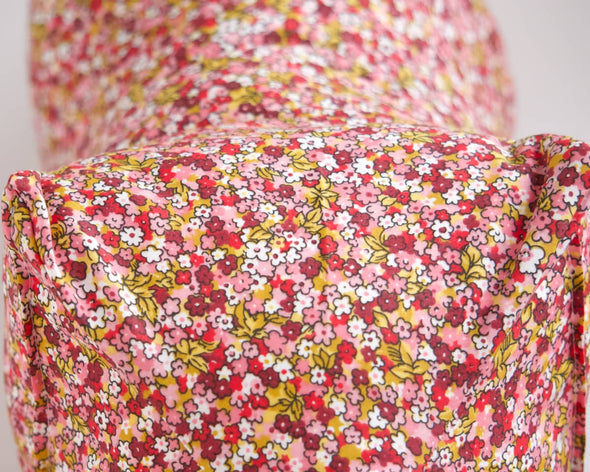 Zoom imprimé petites fleurs roses rouges jaunes du coussin repose-tête